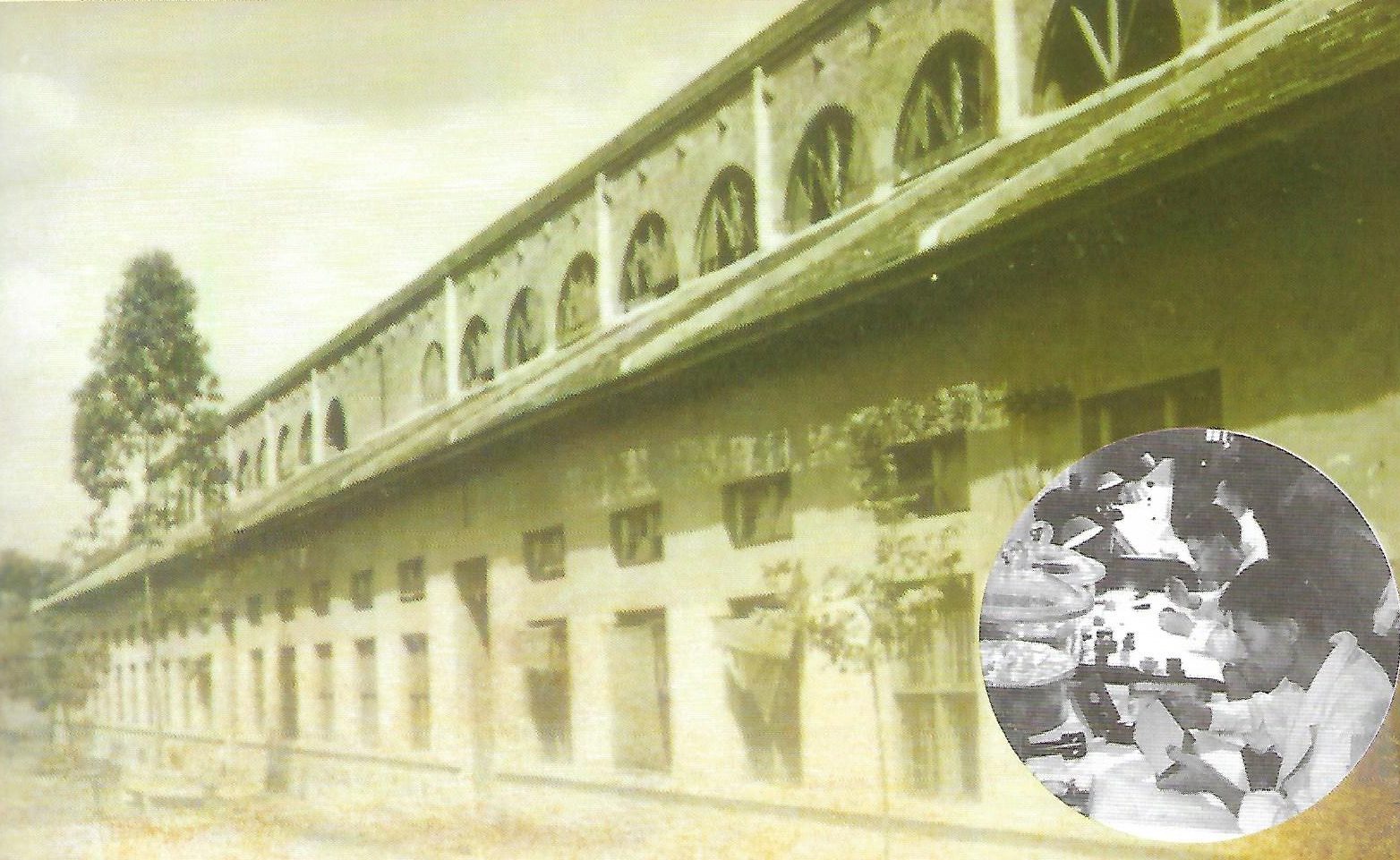 Sepia photograph of the long brick workshop with arched clerestory windows, with an inset of workers at microscope benches